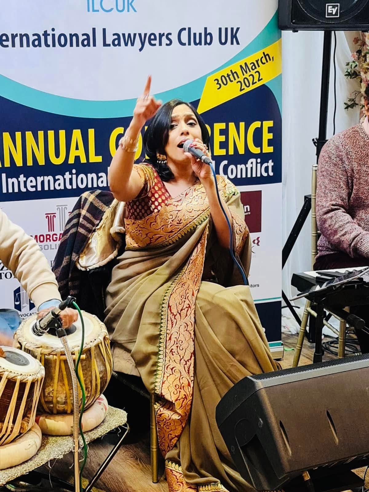 Rowshanara Moni performing seated with tabla accompaniment at the International Lawyers Club UK annual conference