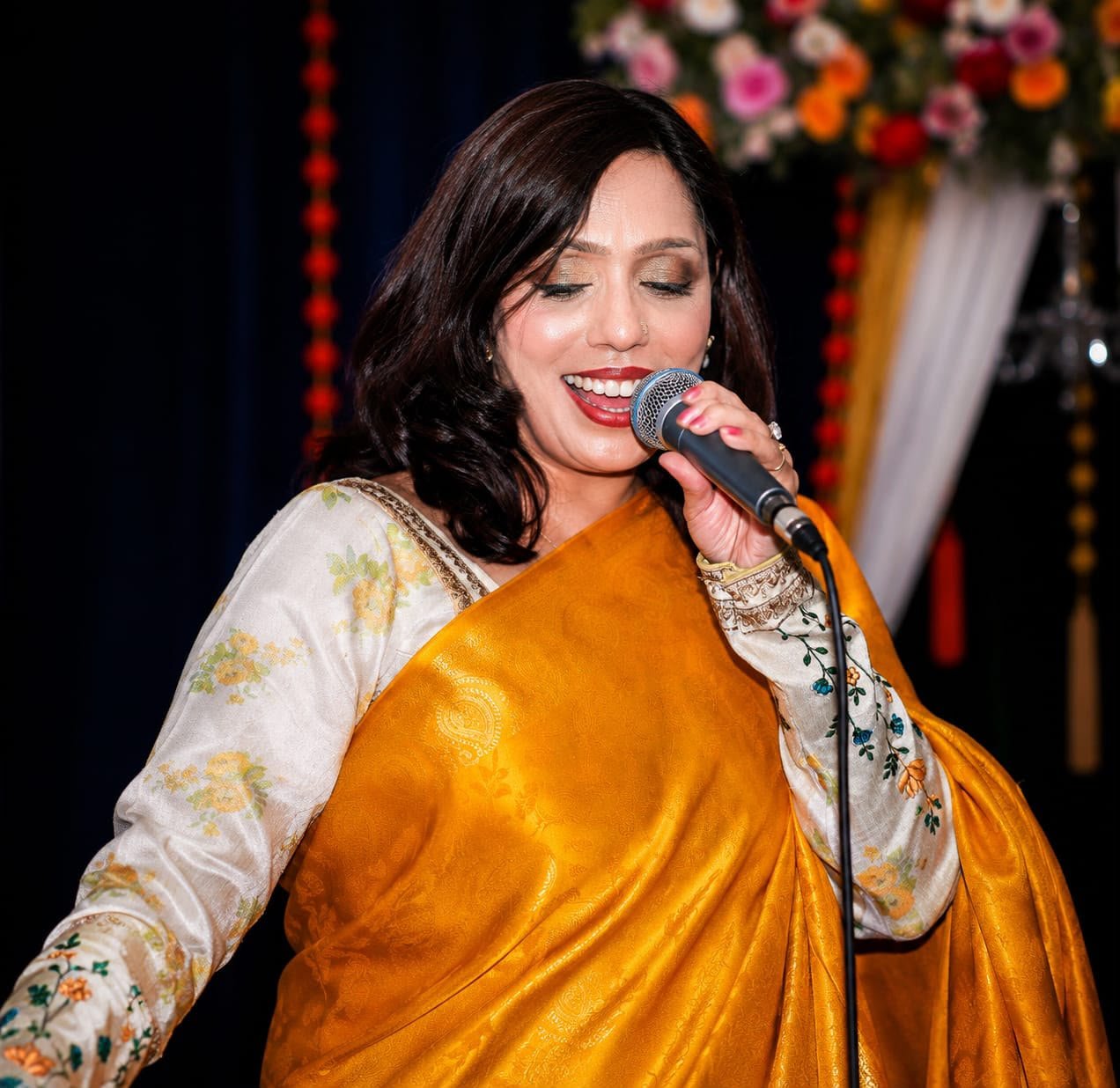 Rowshanara Moni singing close into a microphone
